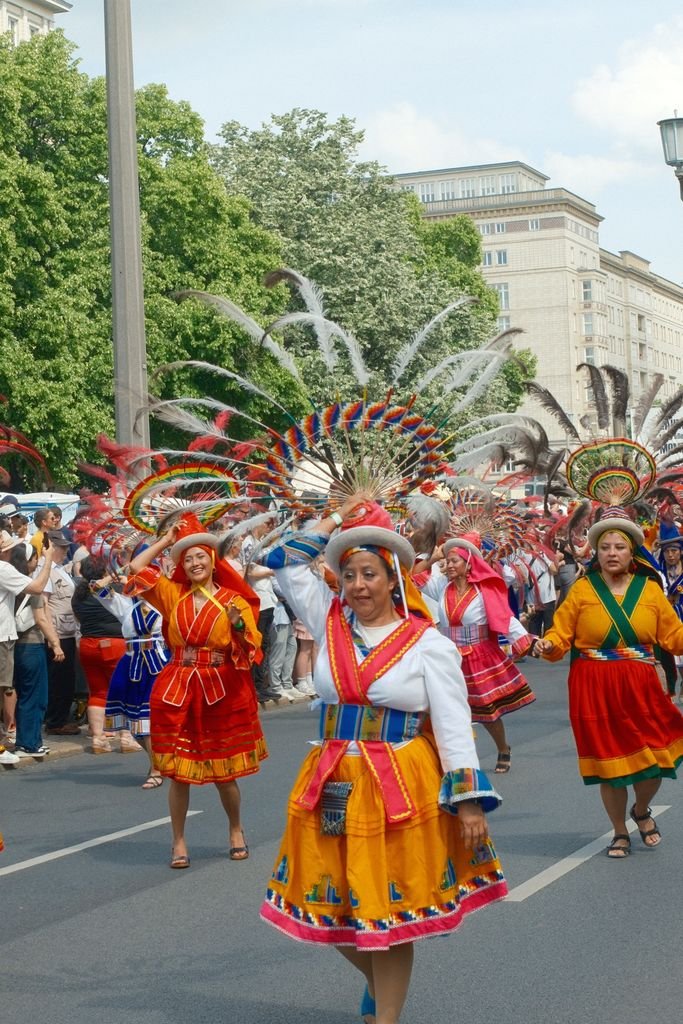 Vibrant traditional dancers in colorful costumes during Berlin's lively street carnival parade.